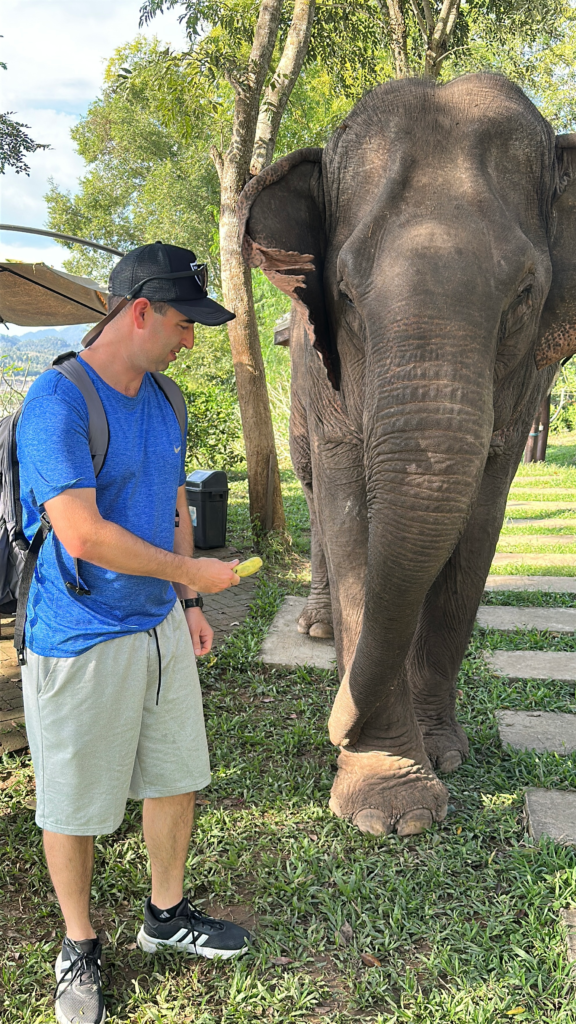 Eric Claggett feeding an elephant in Luang Prabang, Laos.