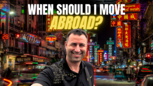 When to move abroad article featured image. eric james of foreign option standing in Bangkok chinatown, text "When Should i move abroad?"
